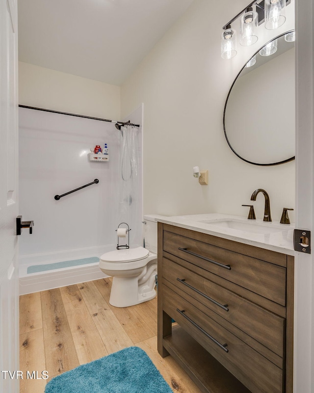 full bathroom with hardwood / wood-style floors, toilet, shower / tub combo, and vanity