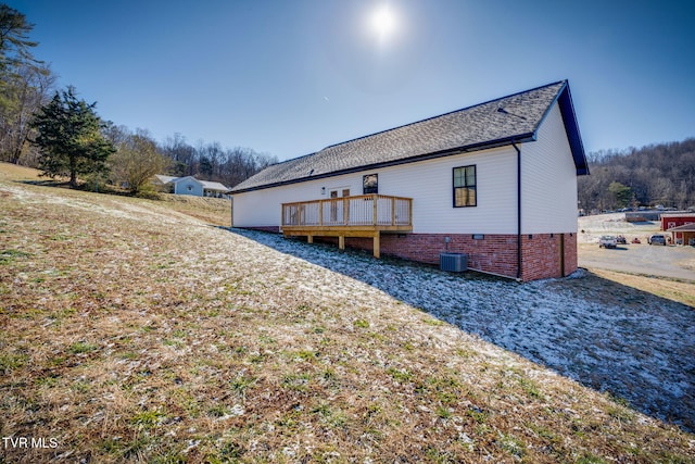 rear view of house with central AC unit and a deck