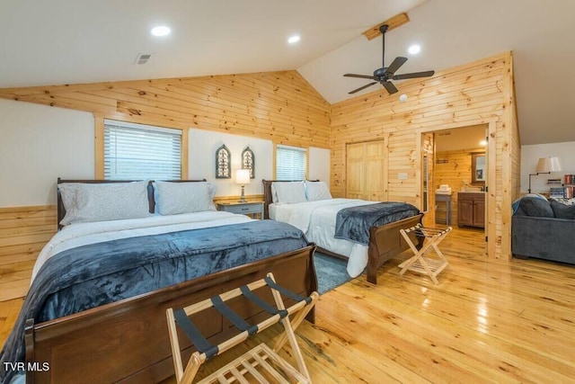 bedroom featuring high vaulted ceiling, light hardwood / wood-style floors, and wood walls