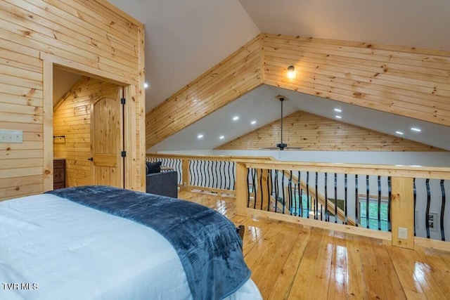 bedroom featuring lofted ceiling, hardwood / wood-style floors, and wooden walls