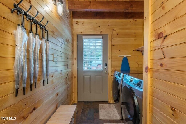 laundry area with washer and dryer, dark wood-type flooring, and wood walls