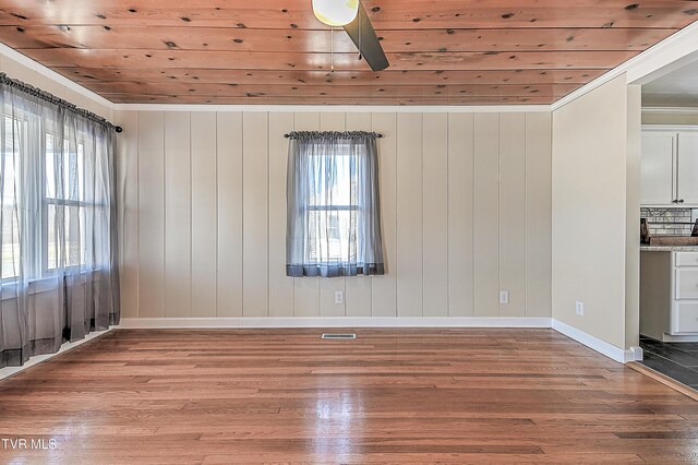 spare room with ornamental molding, ceiling fan, wood ceiling, and hardwood / wood-style floors