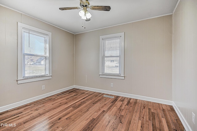 spare room with hardwood / wood-style flooring, crown molding, and ceiling fan