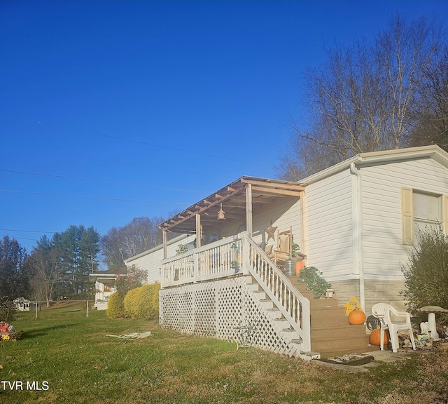 view of side of property featuring a wooden deck and a lawn