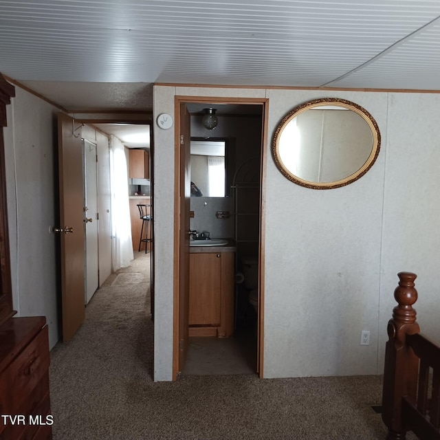 hallway featuring light carpet and sink