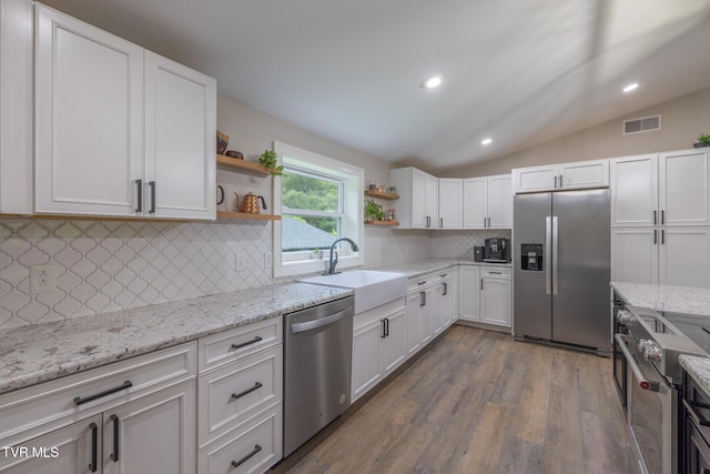 2912 W Walnut St, Johnson City, TN 37604 - kitchen featuring a sink, open shelves, visible vents, vaulted ceiling, and appliances with stainless steel finishes