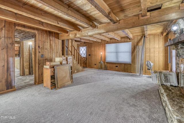 interior space featuring beam ceiling, carpet flooring, wood ceiling, and wooden walls