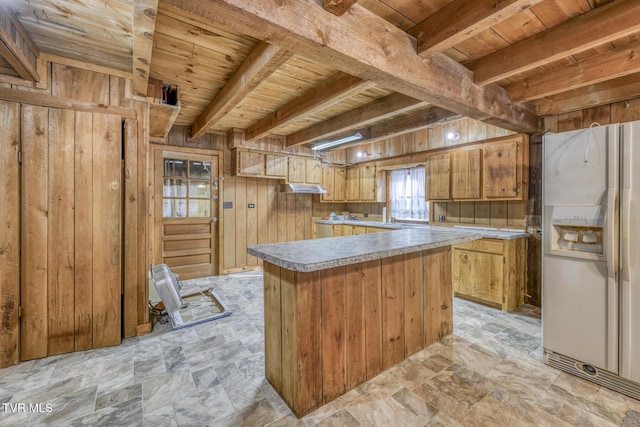 kitchen with wood ceiling, beam ceiling, white refrigerator with ice dispenser, and wood walls