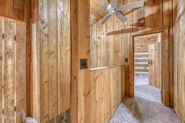 hall featuring carpet floors and wood walls