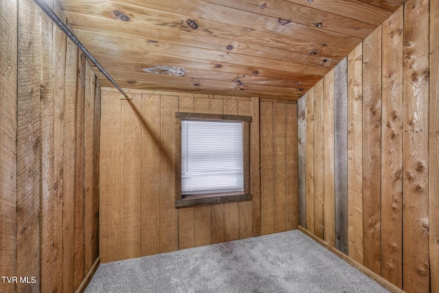 interior space with lofted ceiling, wooden ceiling, carpet, and wood walls