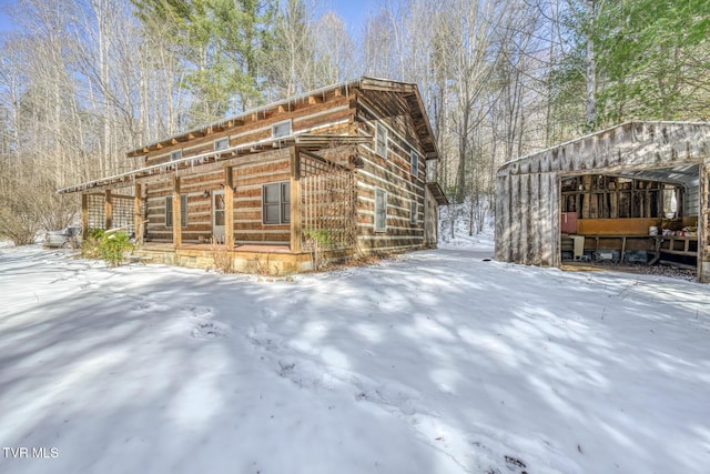 view of snowy exterior with an outbuilding