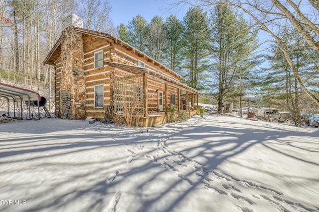 snow covered property featuring a carport