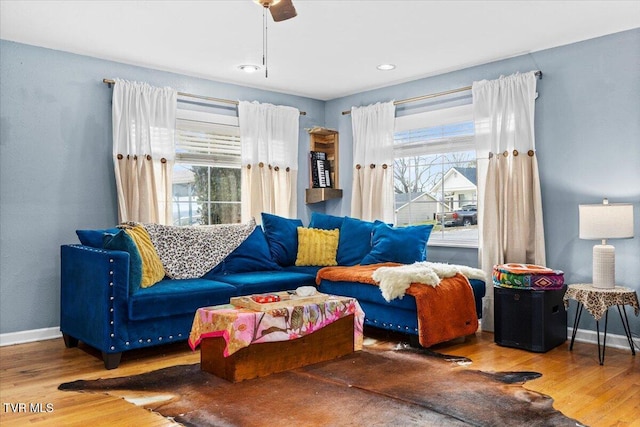 living area with baseboards and wood finished floors