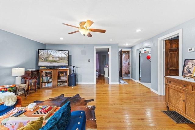 living room featuring a ceiling fan, recessed lighting, light wood-style flooring, and baseboards