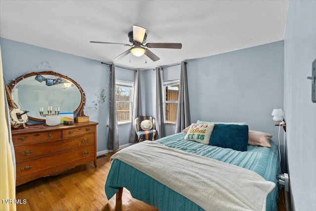 bedroom featuring ceiling fan, wood finished floors, and baseboards