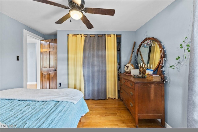 bedroom with light wood-style floors and a ceiling fan