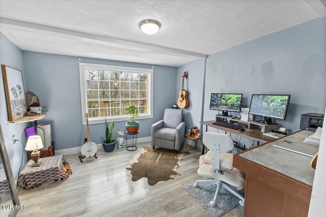 office space featuring a textured ceiling, baseboards, and wood finished floors