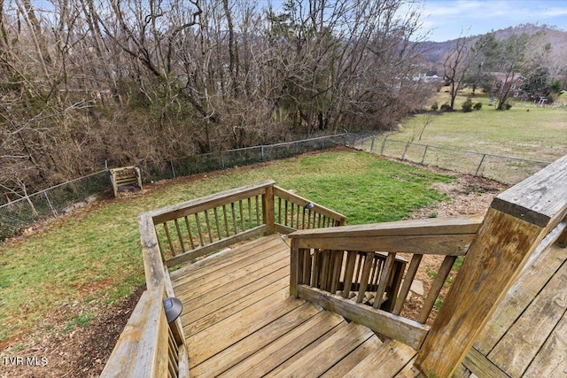 wooden terrace with a fenced backyard, a yard, and a mountain view