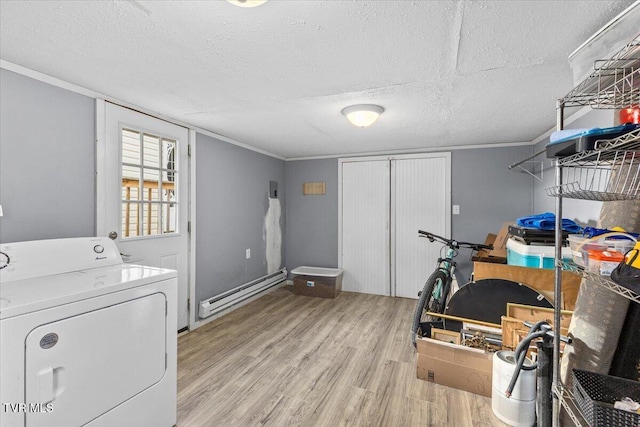 laundry area with laundry area, a baseboard radiator, light wood-style flooring, washer / clothes dryer, and a textured ceiling