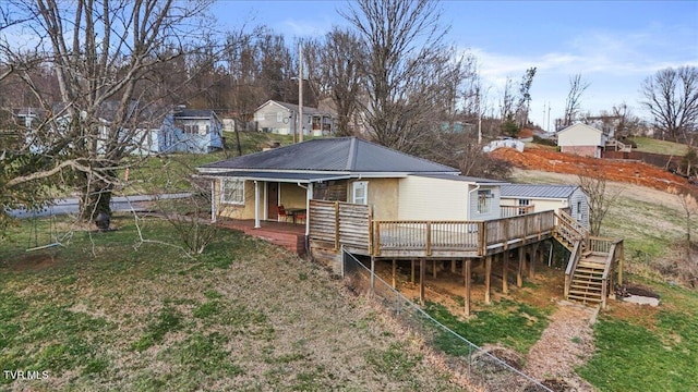 rear view of house featuring stairway, metal roof, and a wooden deck