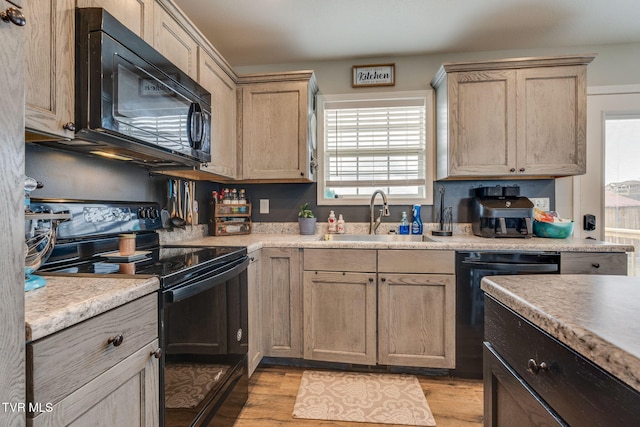 kitchen featuring light hardwood / wood-style floors, sink, light brown cabinets, and black appliances