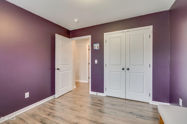 unfurnished bedroom featuring light hardwood / wood-style floors and a closet