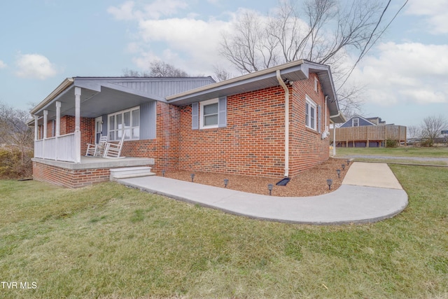 view of side of home with a porch and a yard