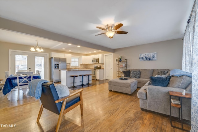 living room featuring french doors, plenty of natural light, and light hardwood / wood-style floors