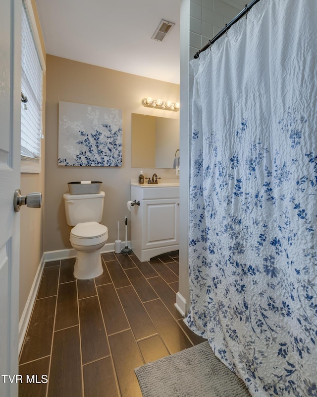 bathroom featuring vanity, toilet, and curtained shower