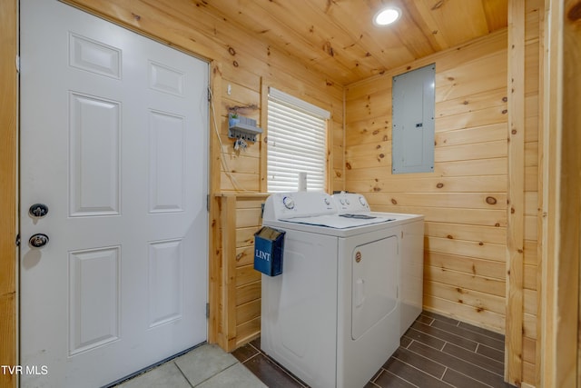 washroom featuring independent washer and dryer, wooden ceiling, electric panel, and wood walls