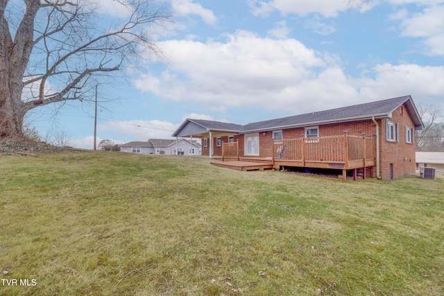 rear view of property featuring a wooden deck, central AC, and a lawn