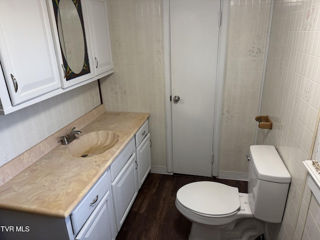 bathroom with vanity, hardwood / wood-style flooring, tile walls, and toilet