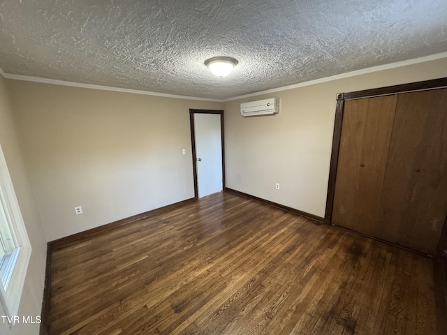 unfurnished bedroom featuring crown molding, dark hardwood / wood-style floors, a wall mounted AC, and a textured ceiling