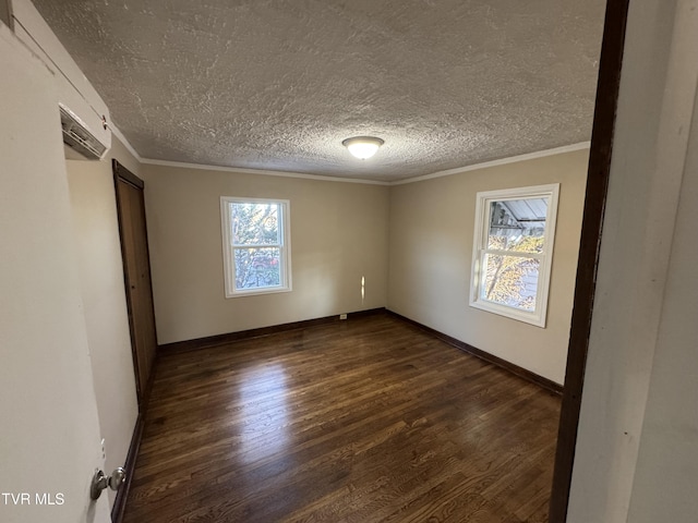 empty room featuring ornamental molding, dark hardwood / wood-style floors, and a textured ceiling