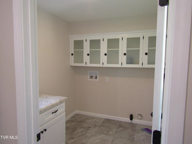 washroom with cabinet space, baseboards, marble finish floor, and hookup for a washing machine