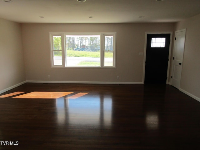 interior space with baseboards, recessed lighting, and dark wood finished floors