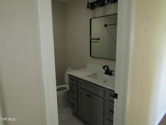 bathroom with vanity, marble finish floor, and toilet