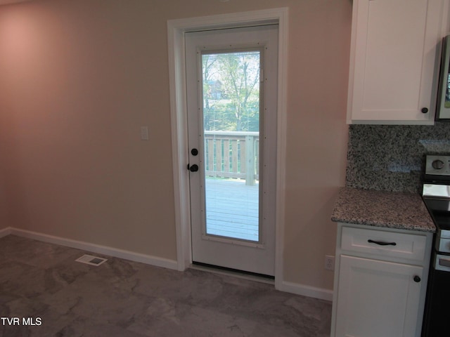 doorway with baseboards and visible vents