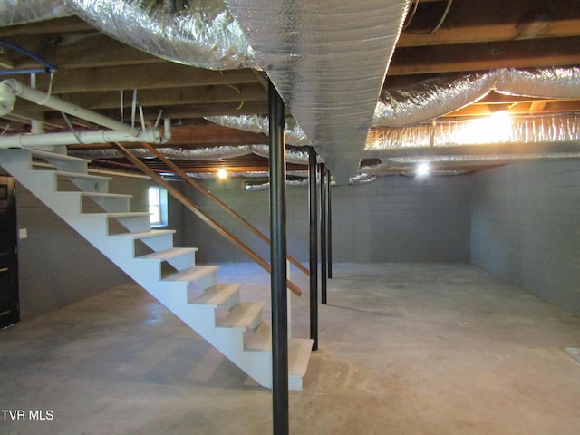 basement with stairs and concrete block wall