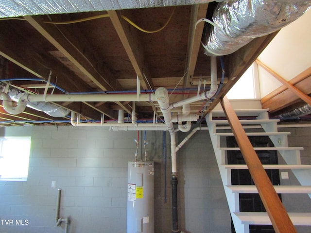 interior space featuring stairway, water heater, and concrete block wall