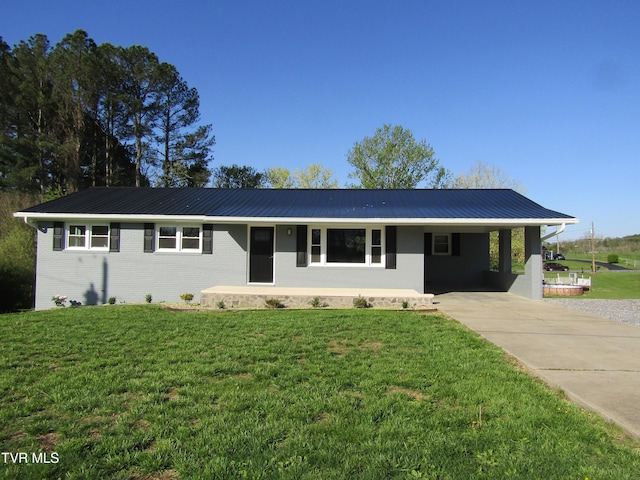 ranch-style house with a front yard, metal roof, and driveway