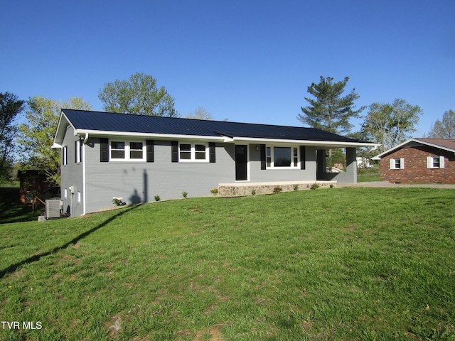 single story home featuring brick siding, a front lawn, cooling unit, and metal roof