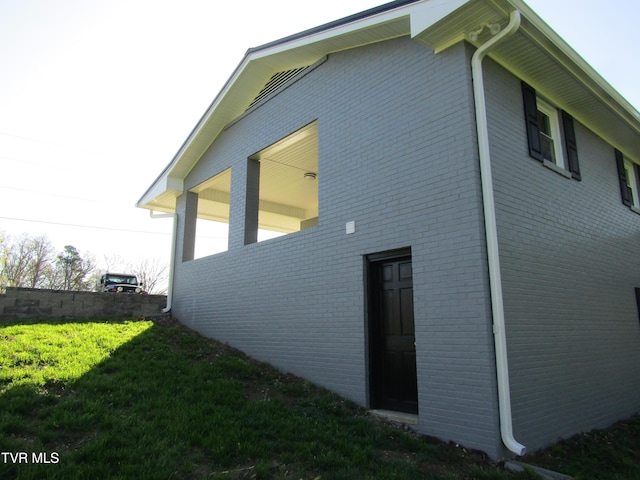 view of home's exterior featuring a yard and brick siding