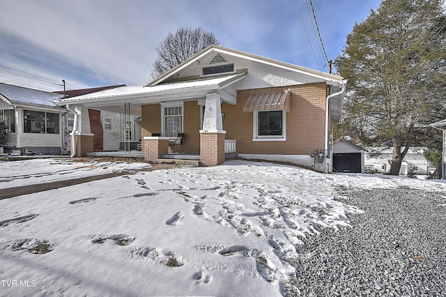 view of front facade featuring an outbuilding, a porch, and a garage