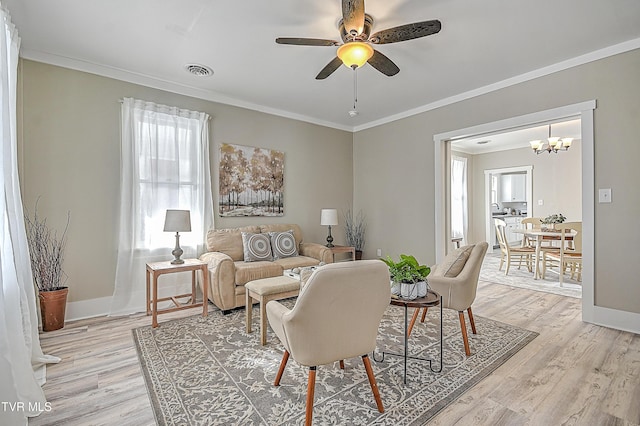 living room with ceiling fan, ornamental molding, and light hardwood / wood-style flooring