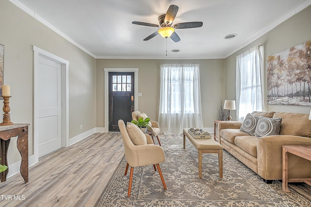 living room with ornamental molding, ceiling fan, and light hardwood / wood-style floors