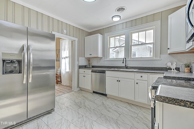 kitchen featuring tasteful backsplash, sink, stainless steel appliances, and white cabinets