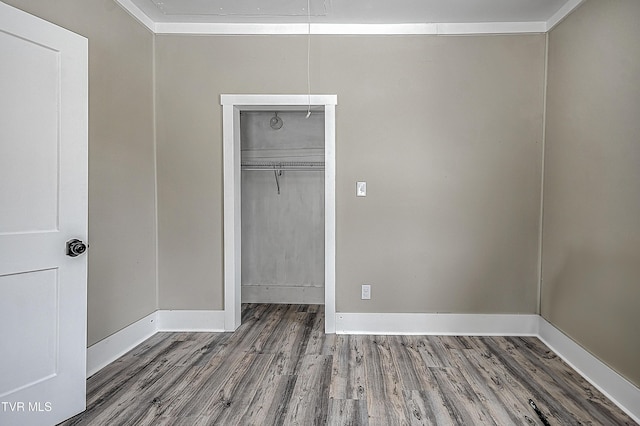 unfurnished bedroom with hardwood / wood-style flooring and a closet