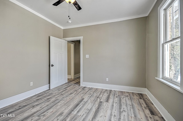 empty room featuring light hardwood / wood-style flooring, ornamental molding, and ceiling fan