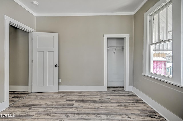 unfurnished bedroom with a closet, ornamental molding, and light hardwood / wood-style flooring